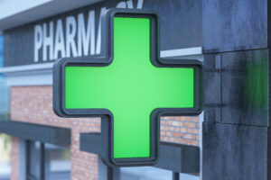 Grünes Kreuz vor einer Apotheke