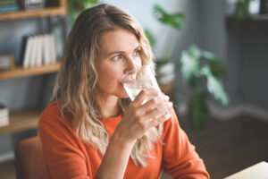 Frau trinkt aus Wasserglas