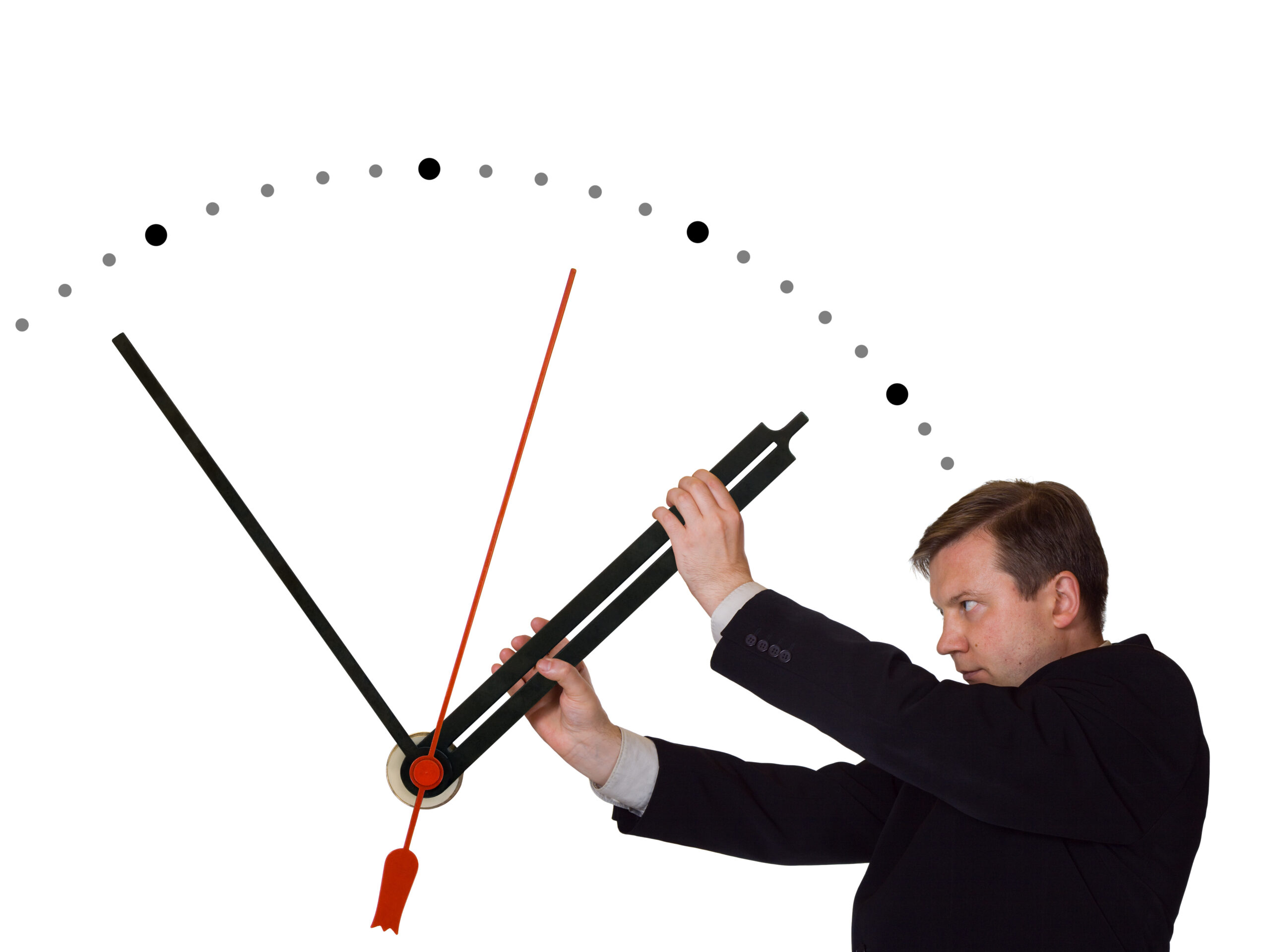 Ein Mann im Anzug hält den Zeiger einer Uhr an.