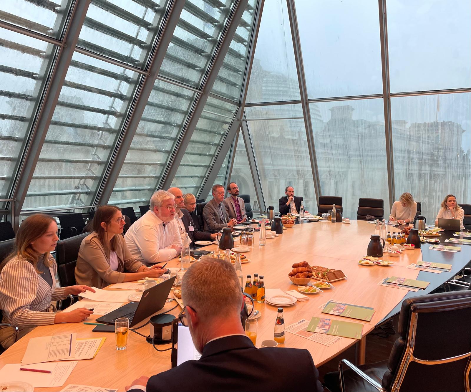 Mehrere Personen sitzen an einem Tisch und diskutieren.