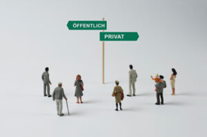 Miniaturfiguren stehen vor einem Wegweiser mit den Richtungen „Öffentlich“ und „Privat“.